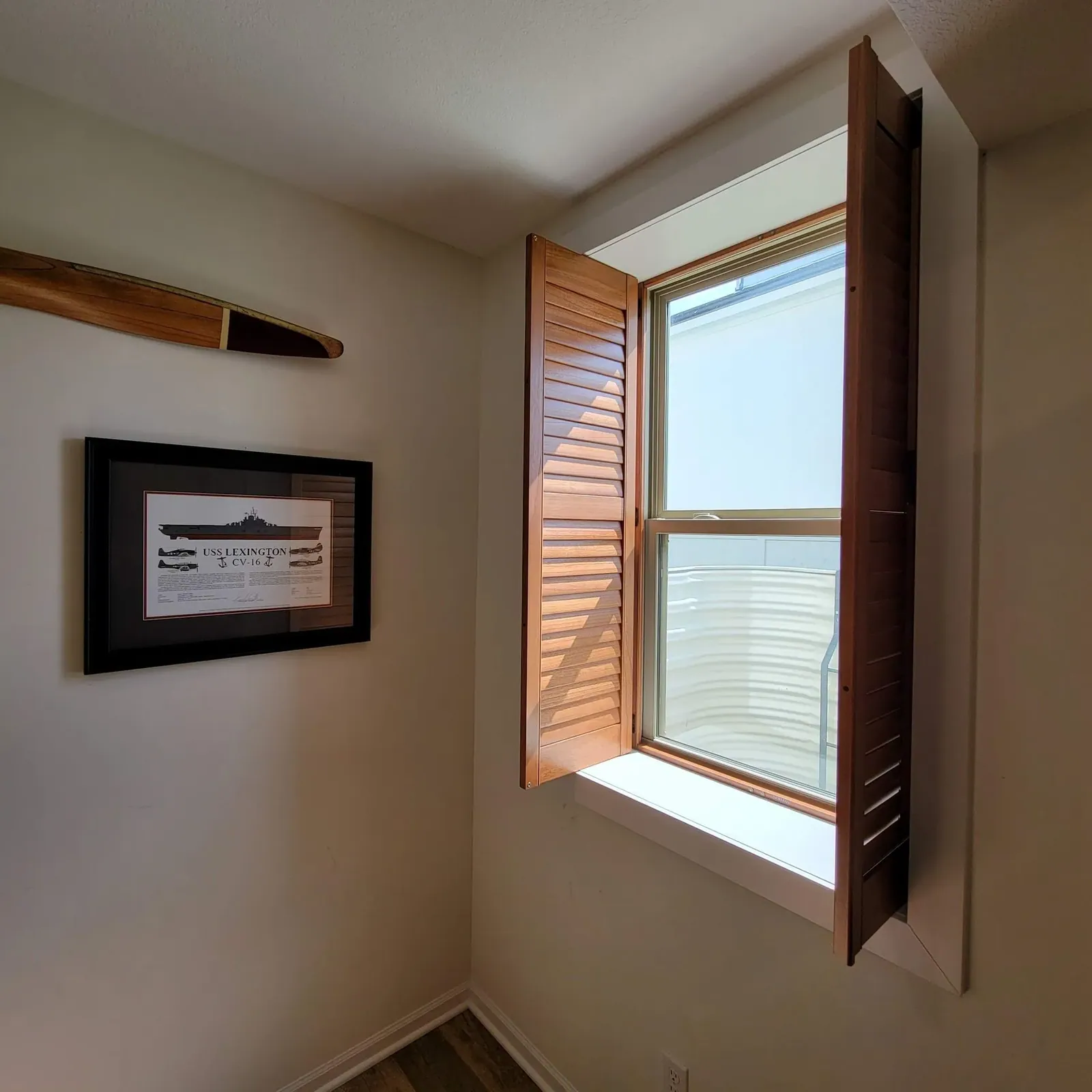 Swung open plantation shutters in bedroom, installed by Solar Shield Blinds