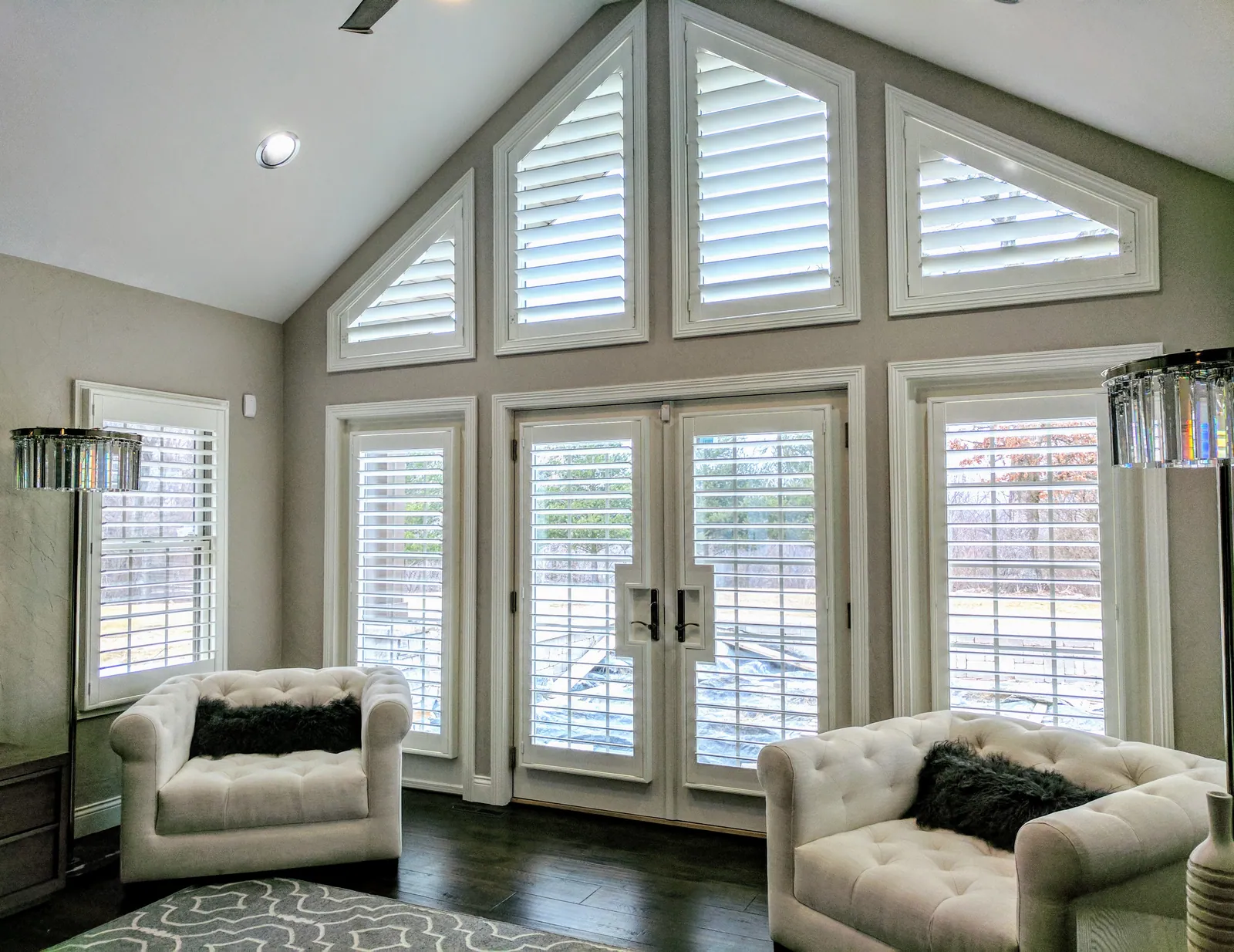 Plantation Shutters on tall windows and a french door cutout in a living room, installed by Solar Shield Blinds