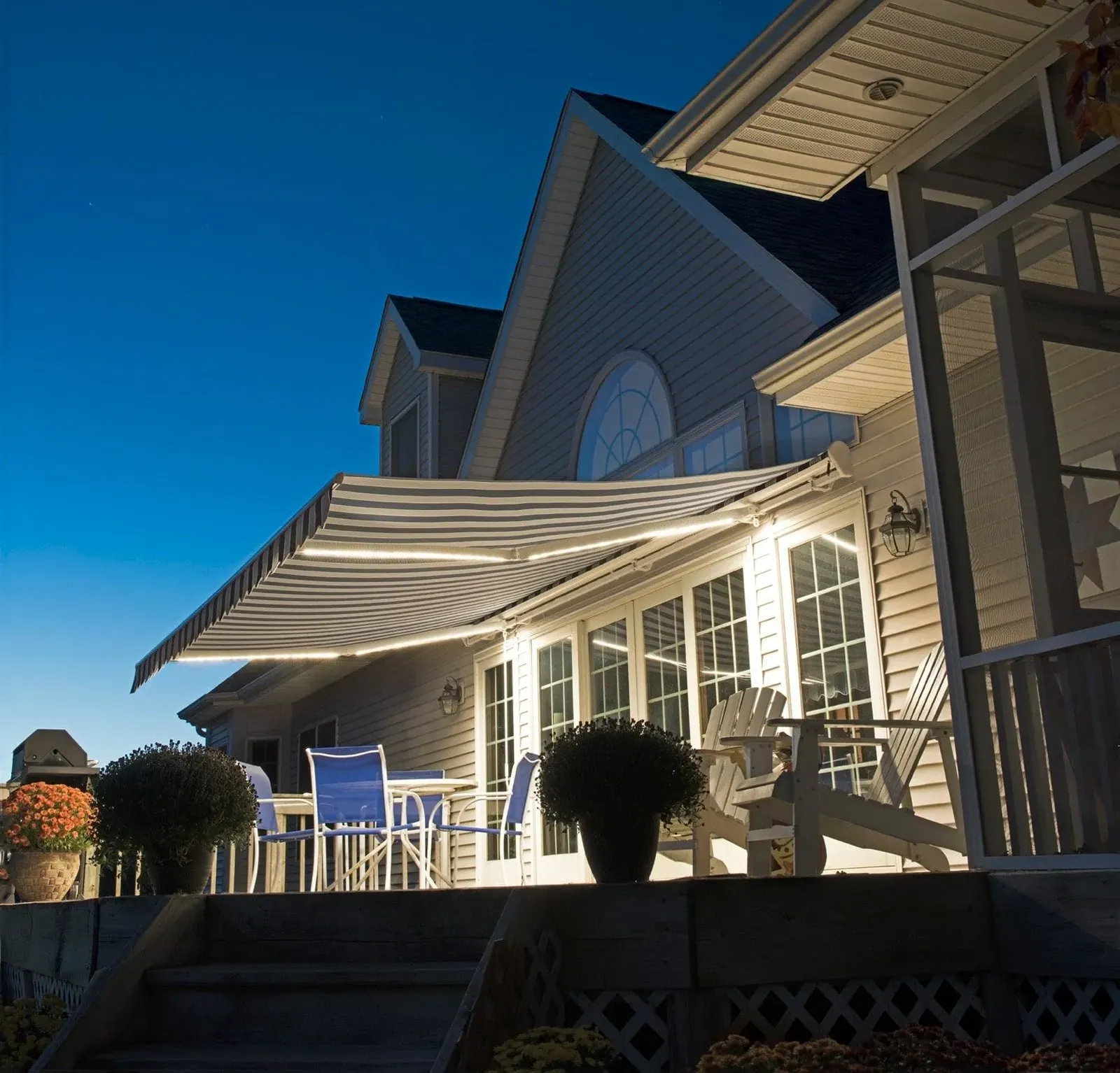 Retractable awning with its built in LED lights lit after dark, installed by Solar Shield Blinds