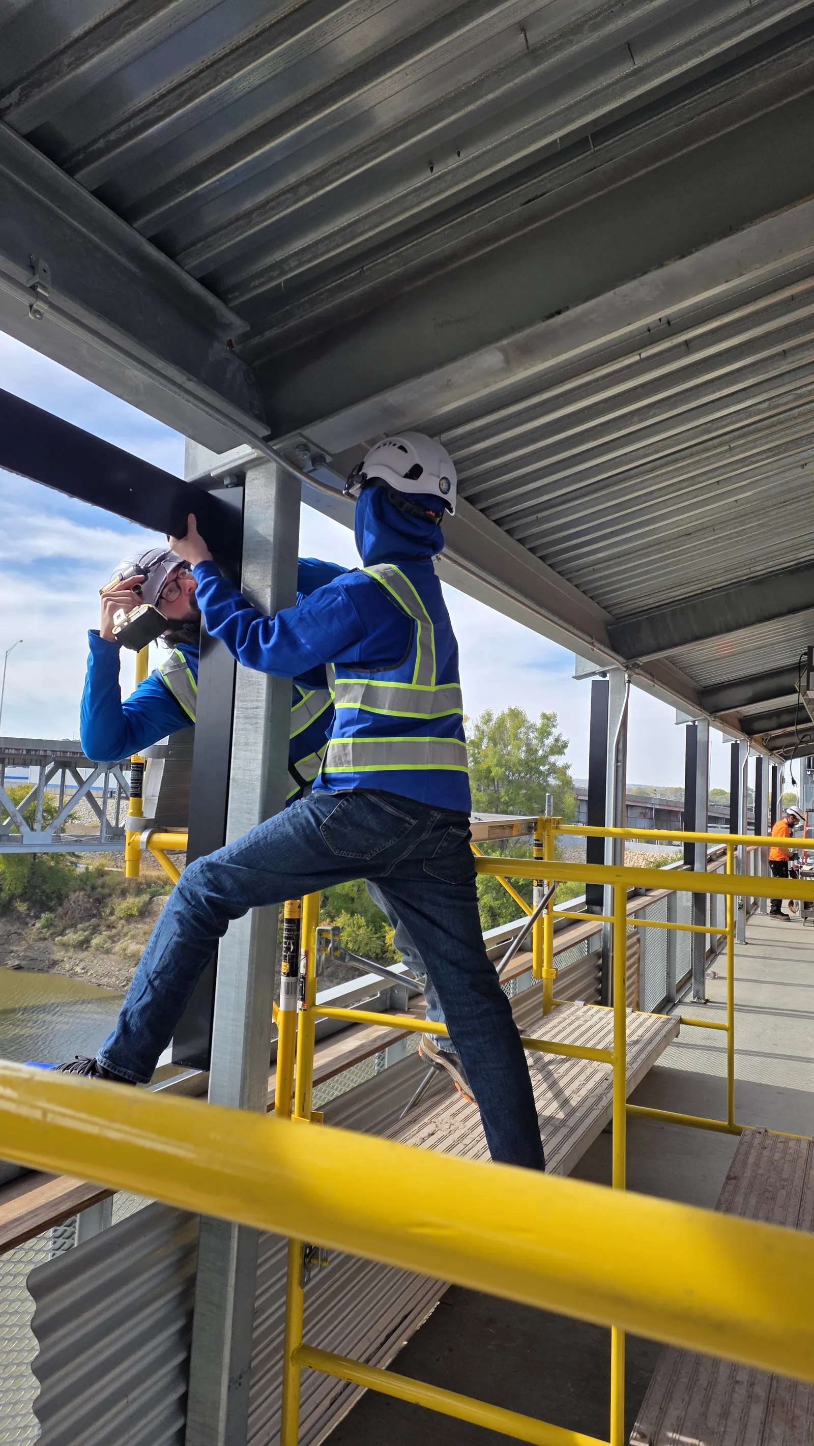 Fixing a shade track to the steel column on the lower level of the bridge