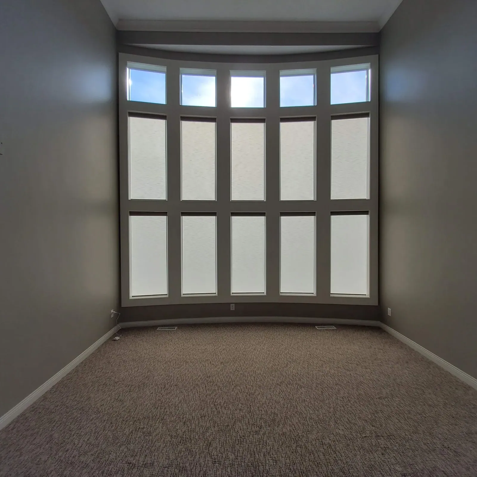 Roller Shades closed in a living room, measured and hung by Solar Shield Blinds