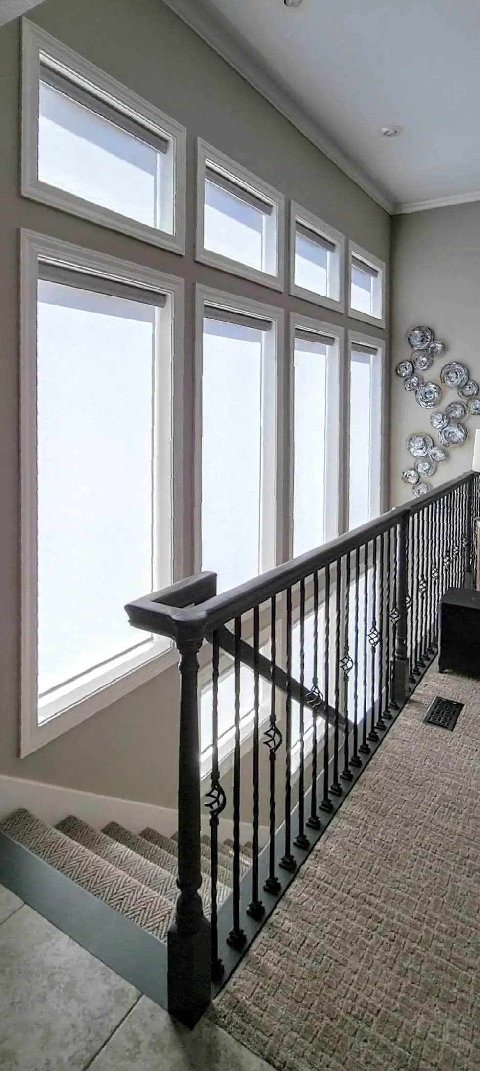Custom roller shades closed in a staircase, installed by Solar Shield Blinds