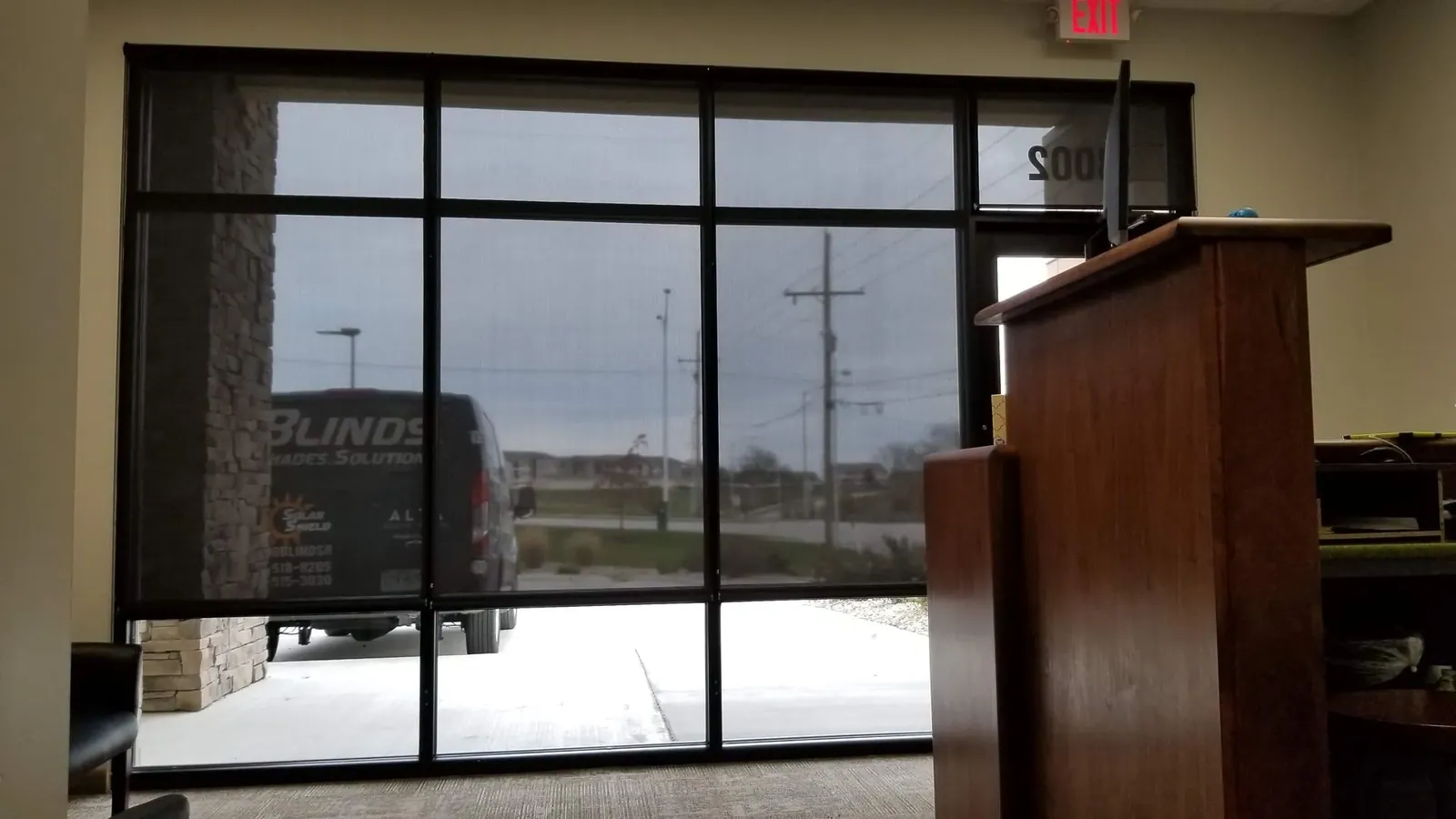 Roller Shades half closed in a commercial building, measured and hung by Solar Shield Blinds