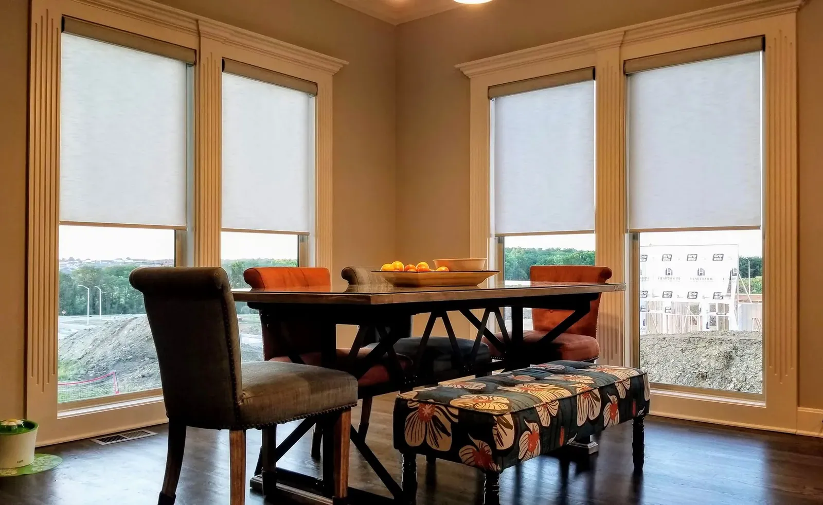 Roller Shades half closed in a dining room, installed by Solar Shield Blinds