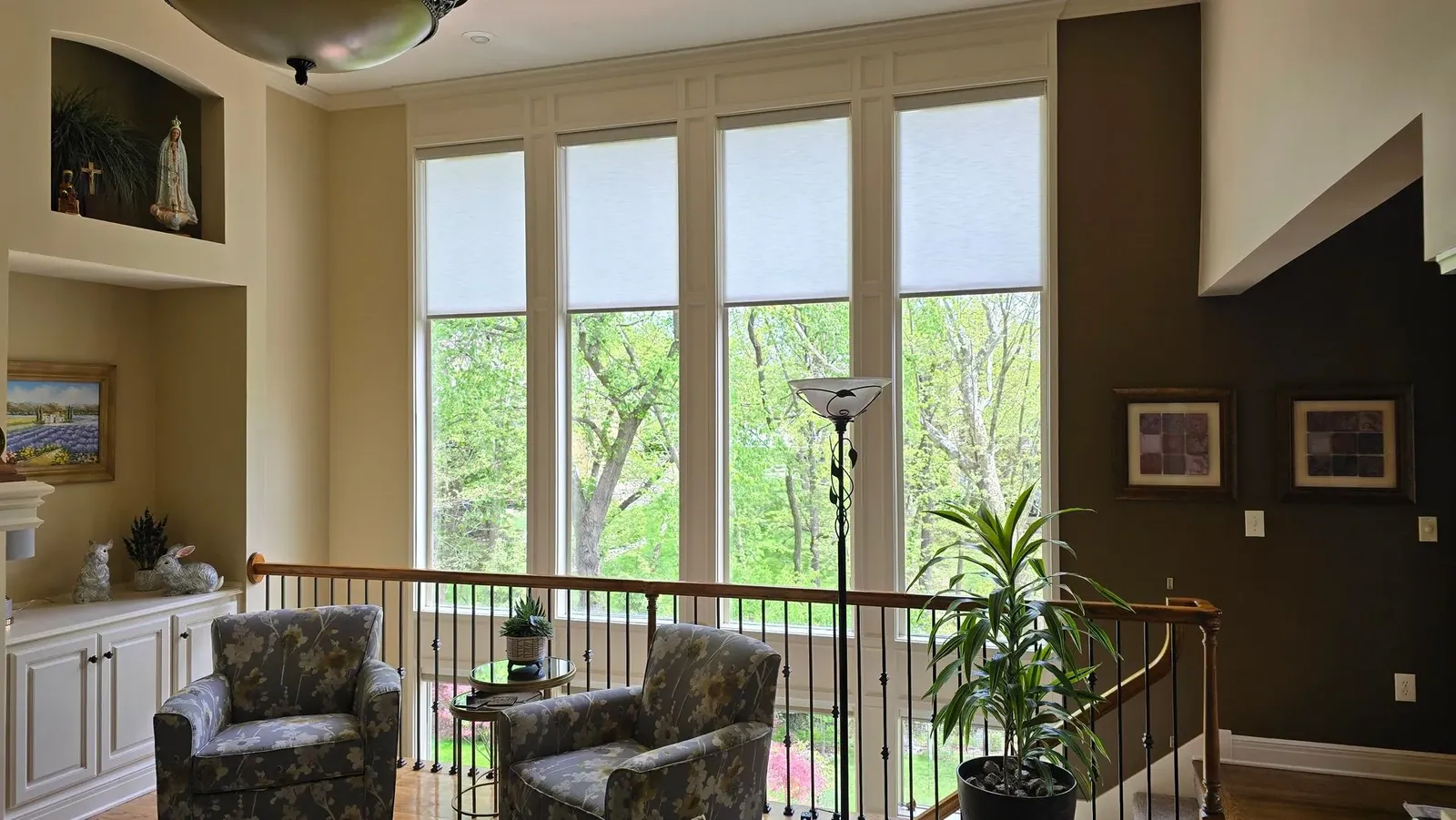 Custom roller shades half closed in a foyer loft, installed by Solar Shield Blinds