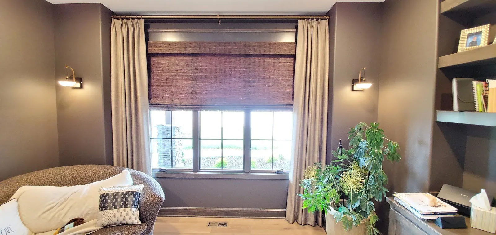 Drapery panels framing a natural woven shade in a home office