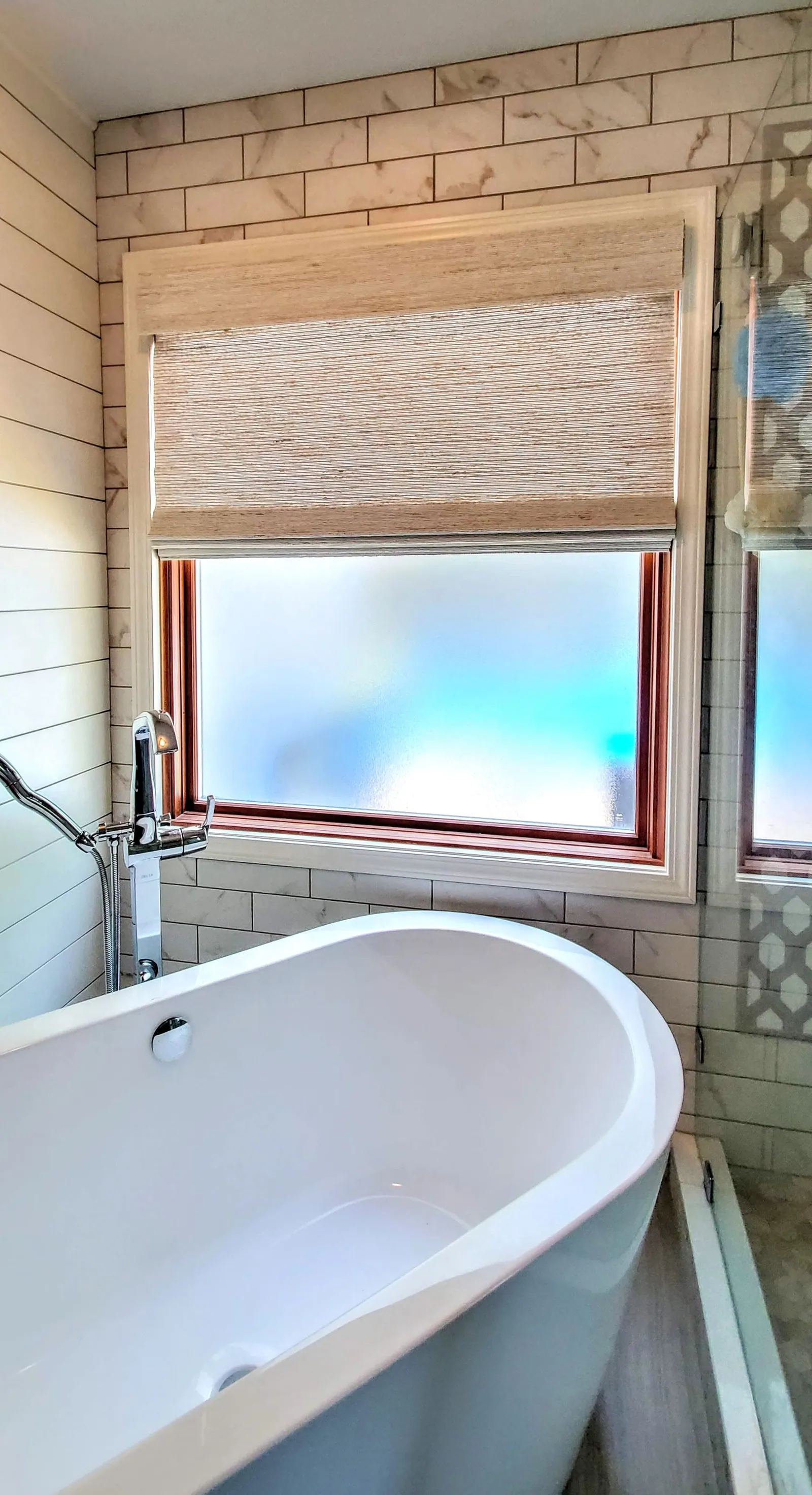 Natural Woven Shade over a freestanding bathtub, installed by Solar Shield Blinds