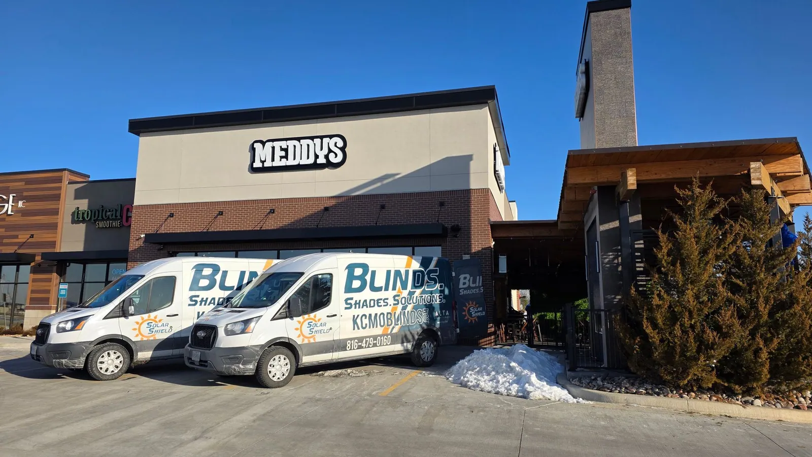 Two Solar Shield Blinds vans parked outside Meddy's on install day