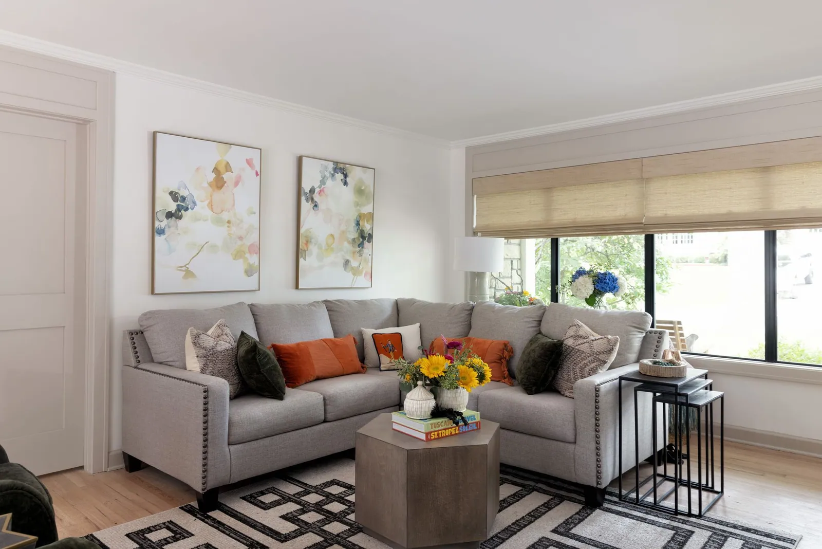 A natural woven shade over a wide living room window
