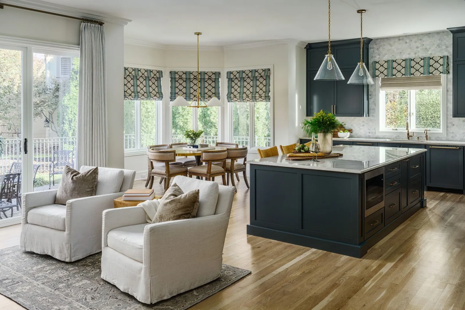 Patterned Roman shades over the windows of an open kitchen and sitting area