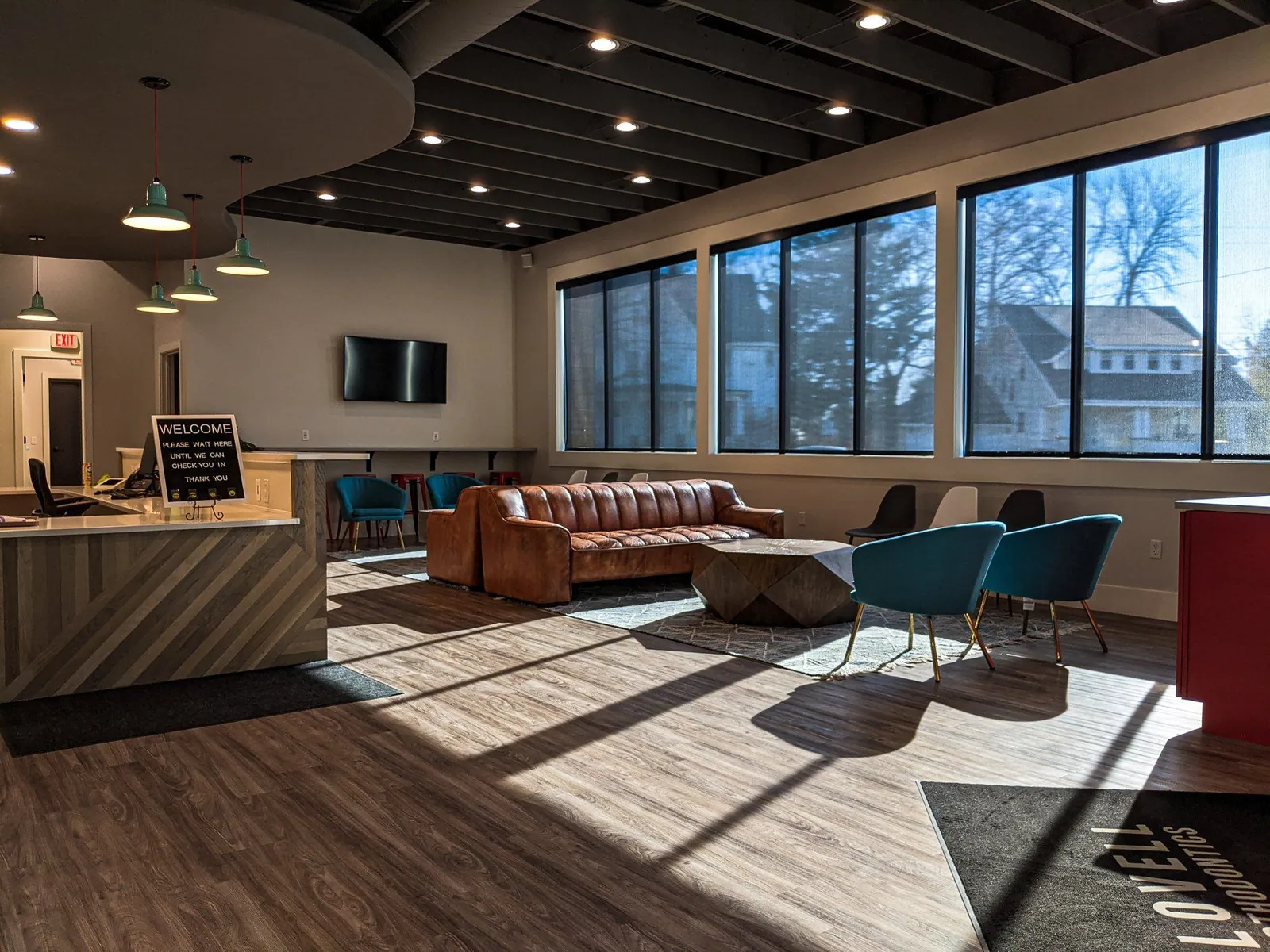 Motorized shades lowered along a row of windows in an open room