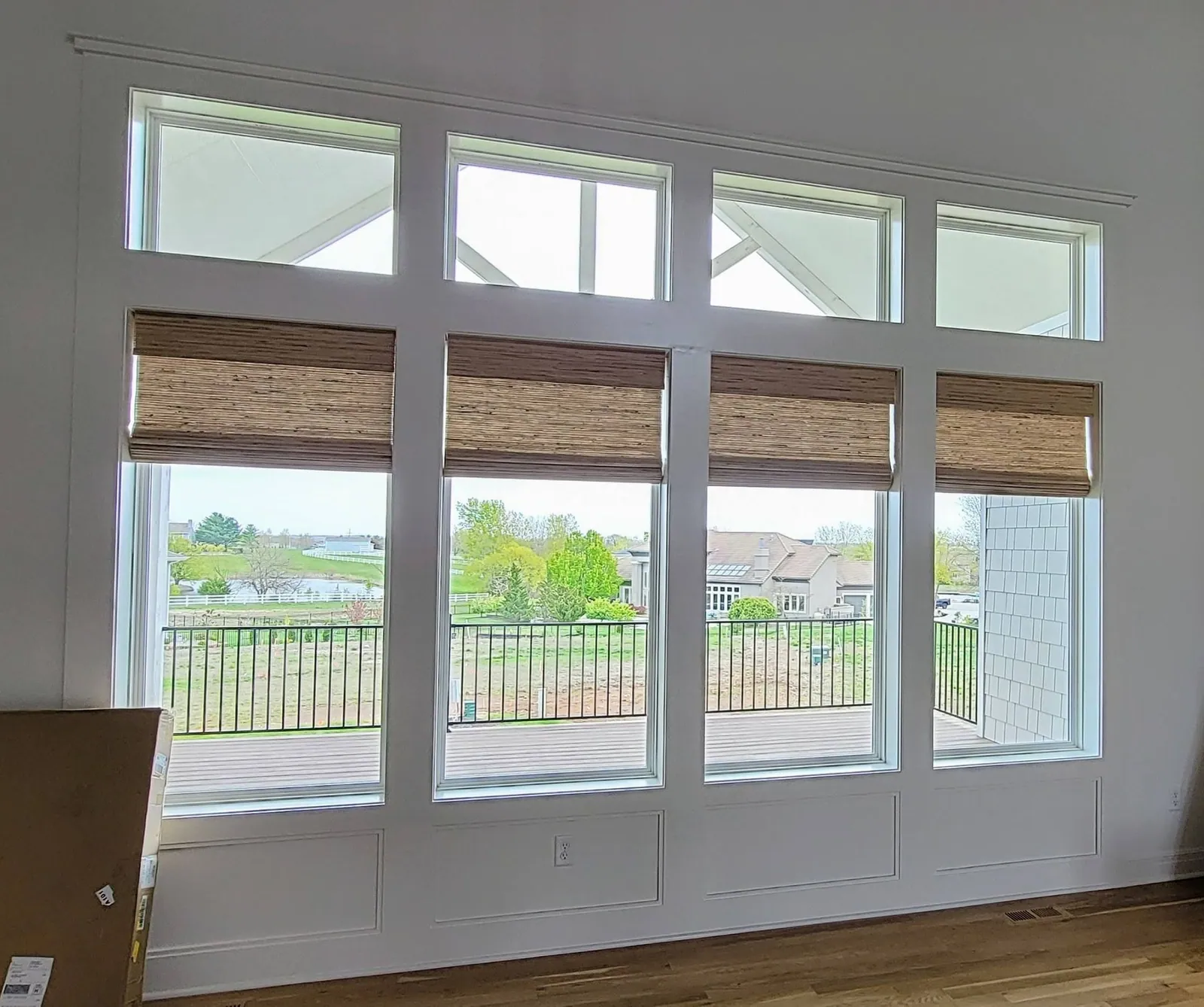 Natural Woven Shades across a wall of living room windows, installed by Solar Shield Blinds