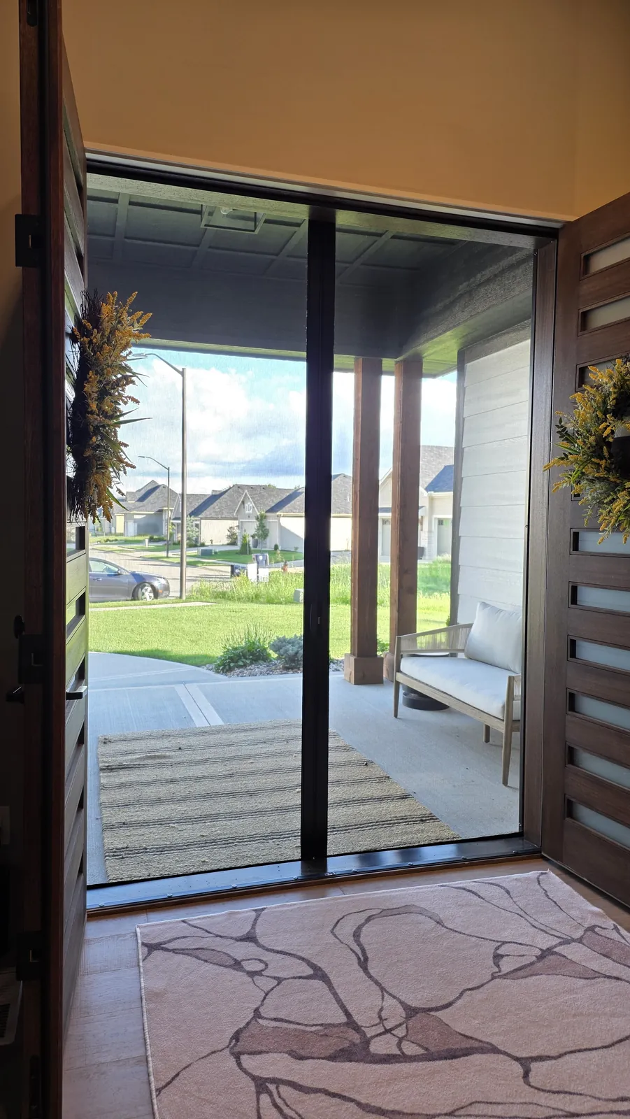 Sliding Screens closed across open double front doors, seen from the entry, with the porch and street beyond
