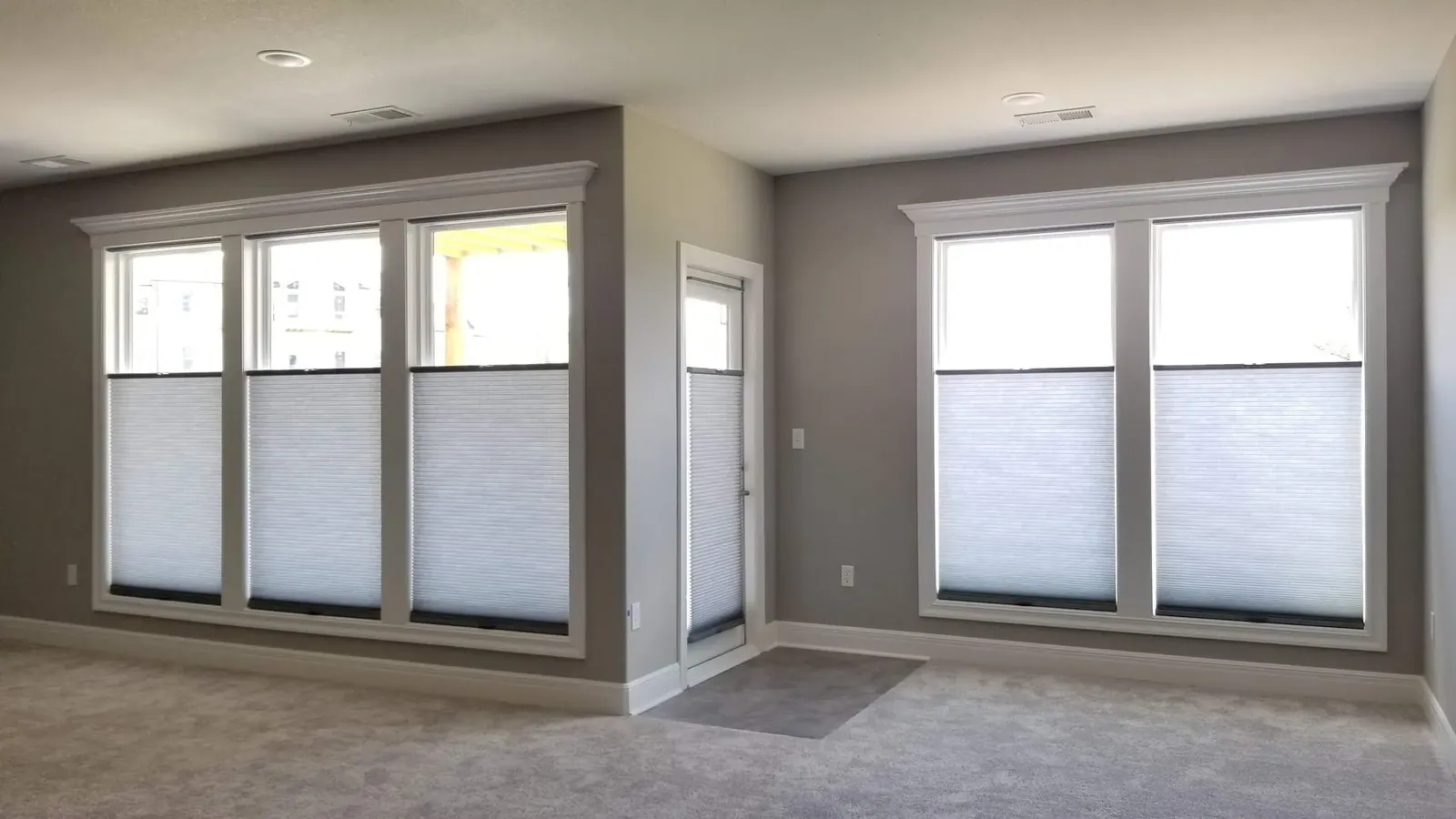 Top Down Bottom Up honeycomb shades on the windows and swing door of a family room