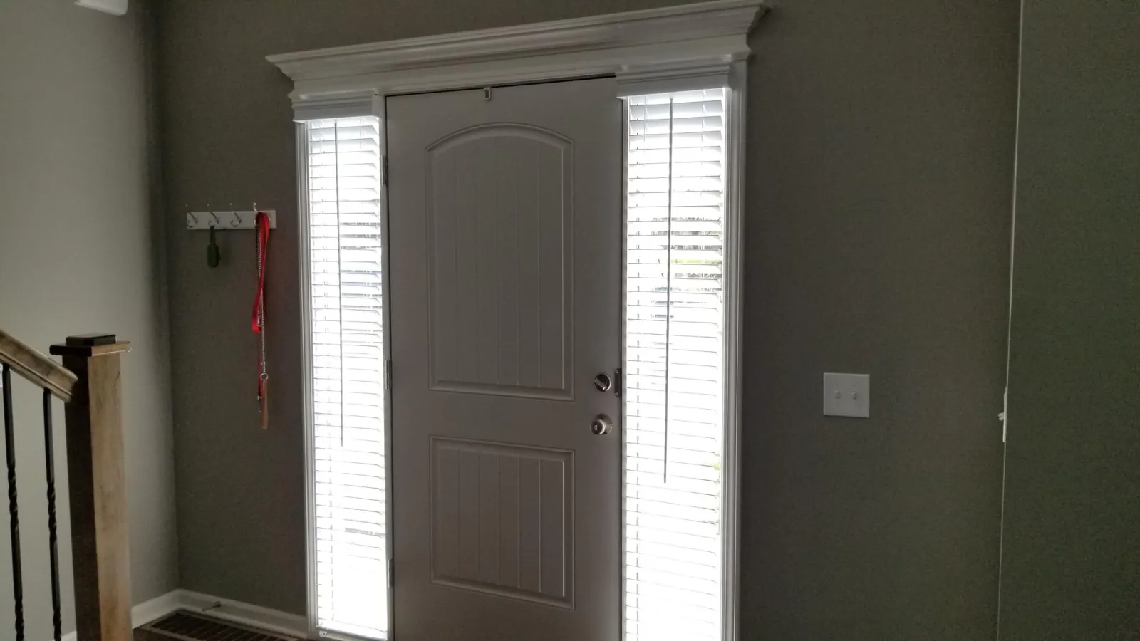 Faux Wood Blinds tilted closed on a pair of sidelights beside a front door