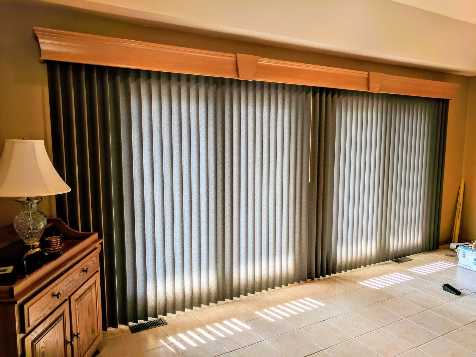Vertical Blinds under a wood cornice across a wide sliding glass door