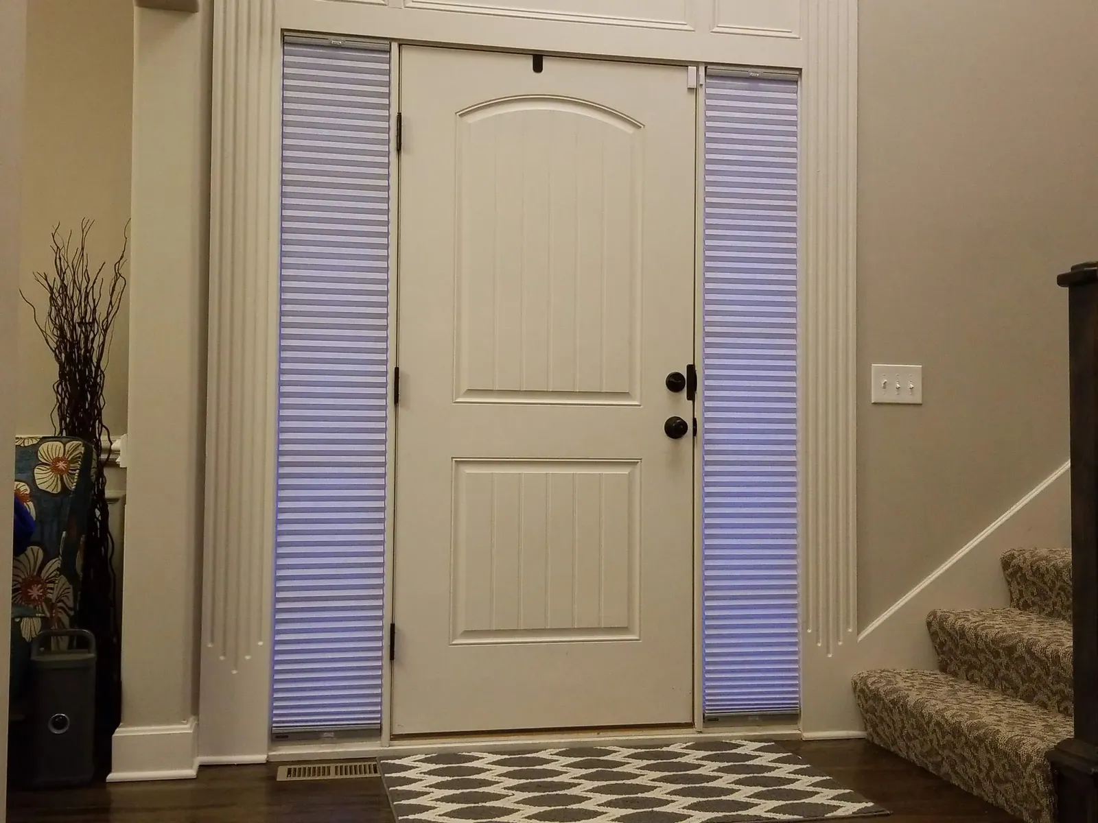 Honeycomb Shades lowered on both sidelights at dusk