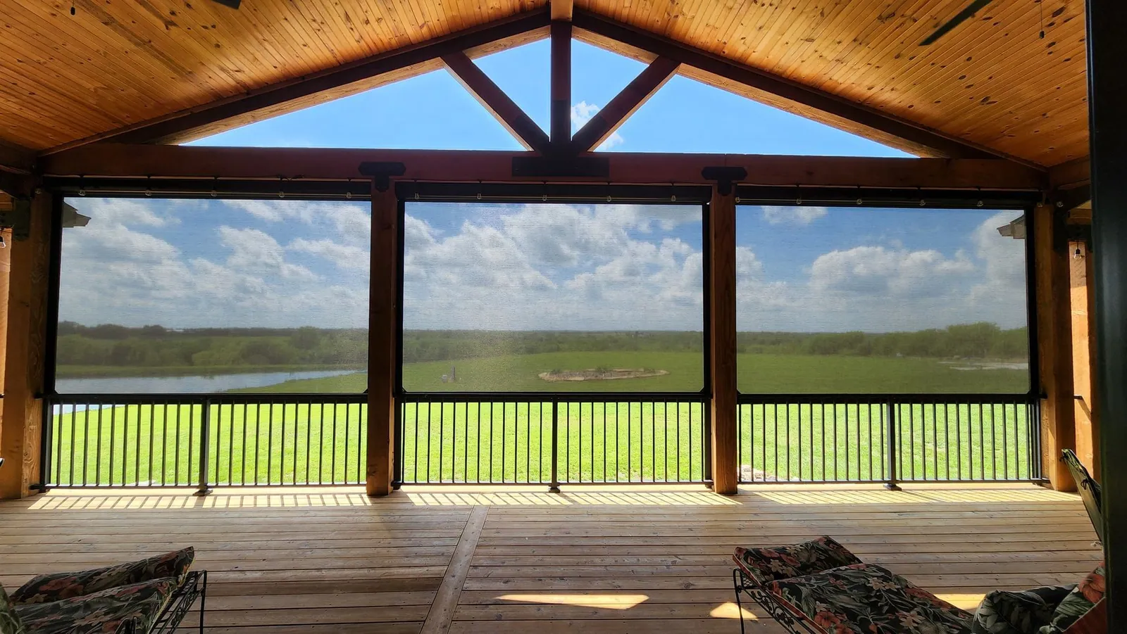 Wide view of the same covered deck with all three screens down, installed by Solar Shield Blinds