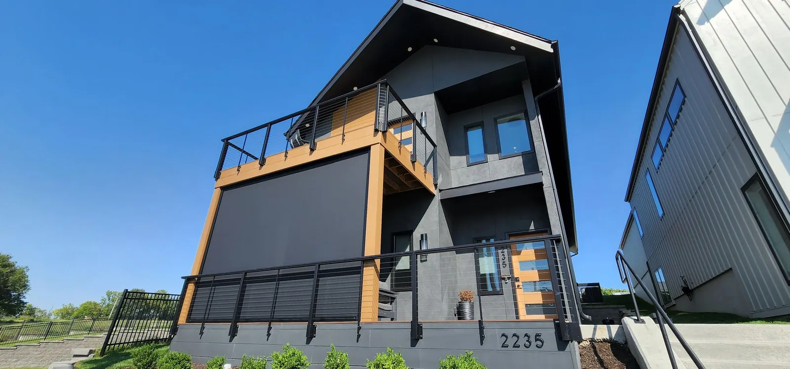 Modern home with the upper deck shade lowered, installed by Solar Shield Blinds