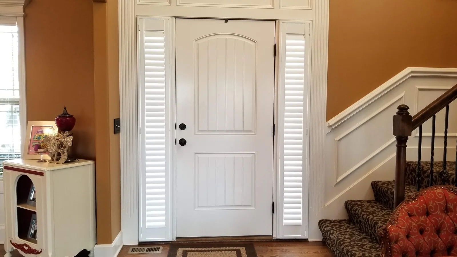 Plantation shutters closed on both sidelights of a front door