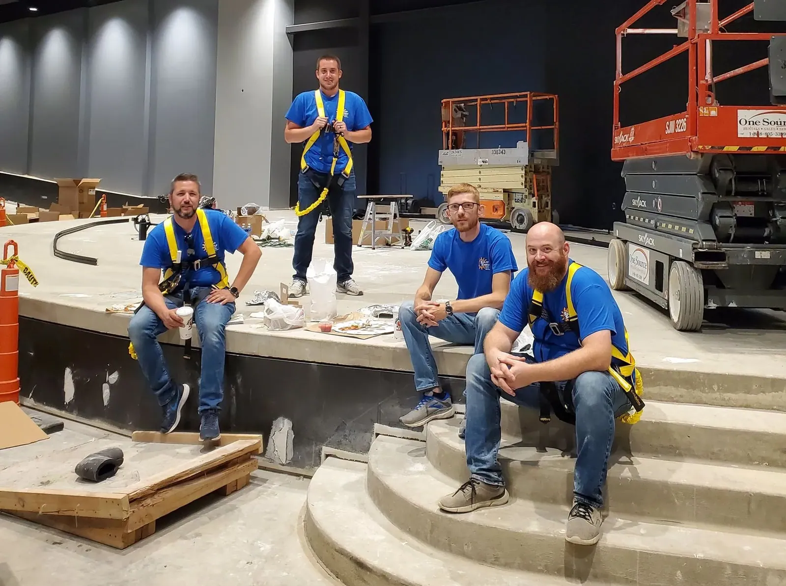 The Solar Shield Blinds crew hanging stage curtains in an auditorium