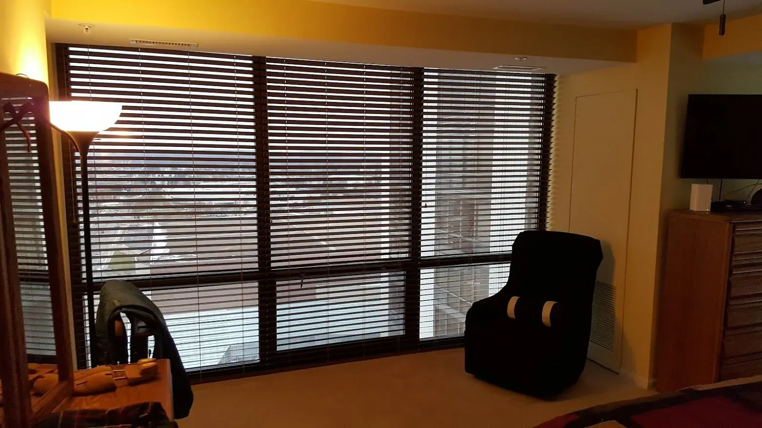 Dark blinds across a wide window in a commercial room