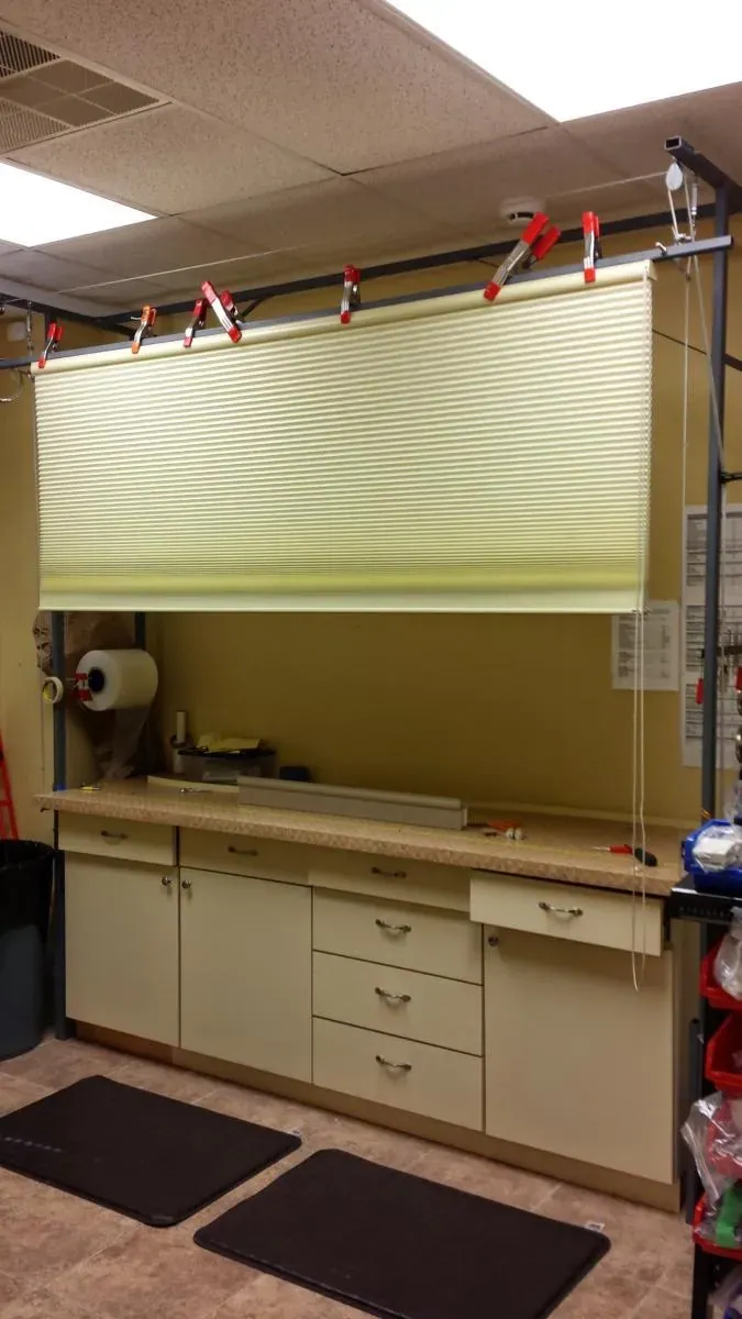 A shade clamped onto the test rig above the workbench at the shop