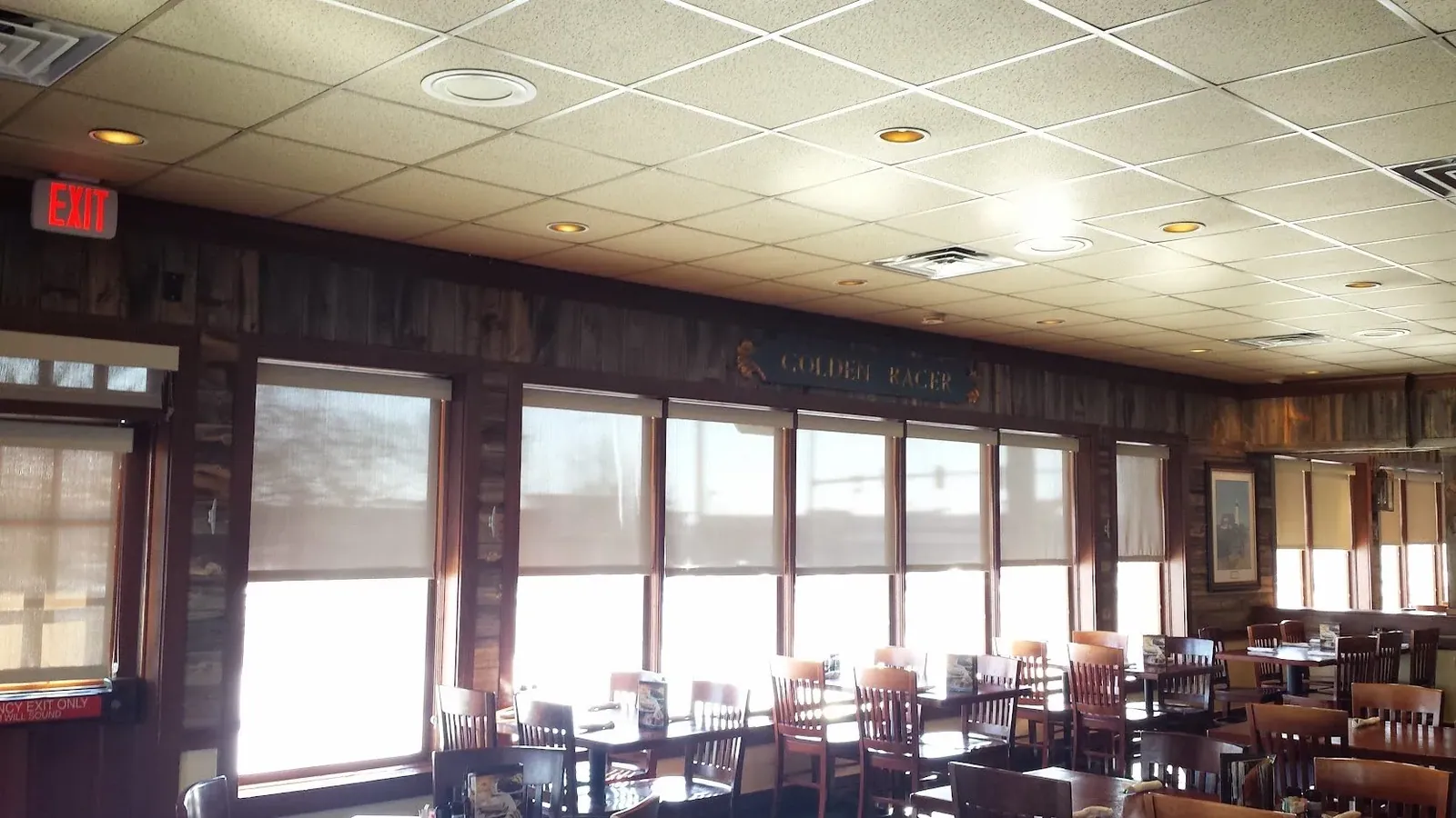 Roller Shades along a restaurant dining room, installed by Solar Shield Blinds