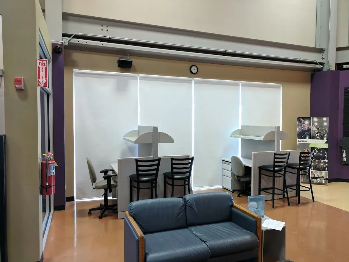Roller Shades behind a study area in a commercial building, installed by Solar Shield Blinds