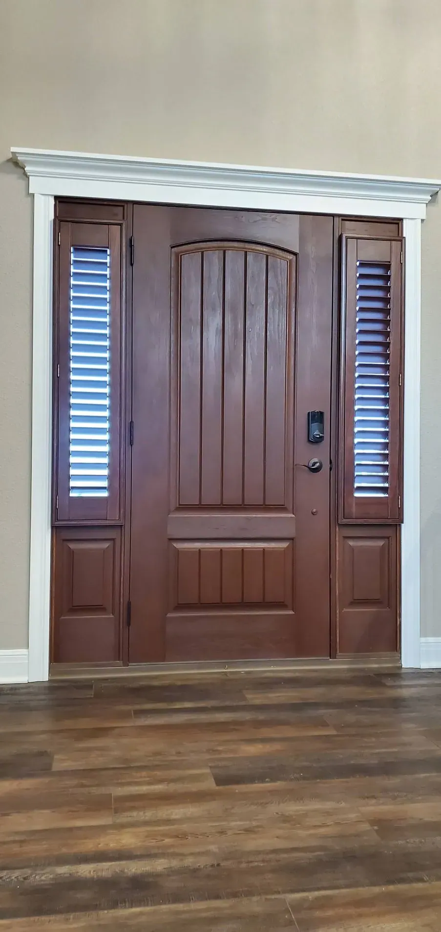 Shutters on both sidelights of a stained wood door