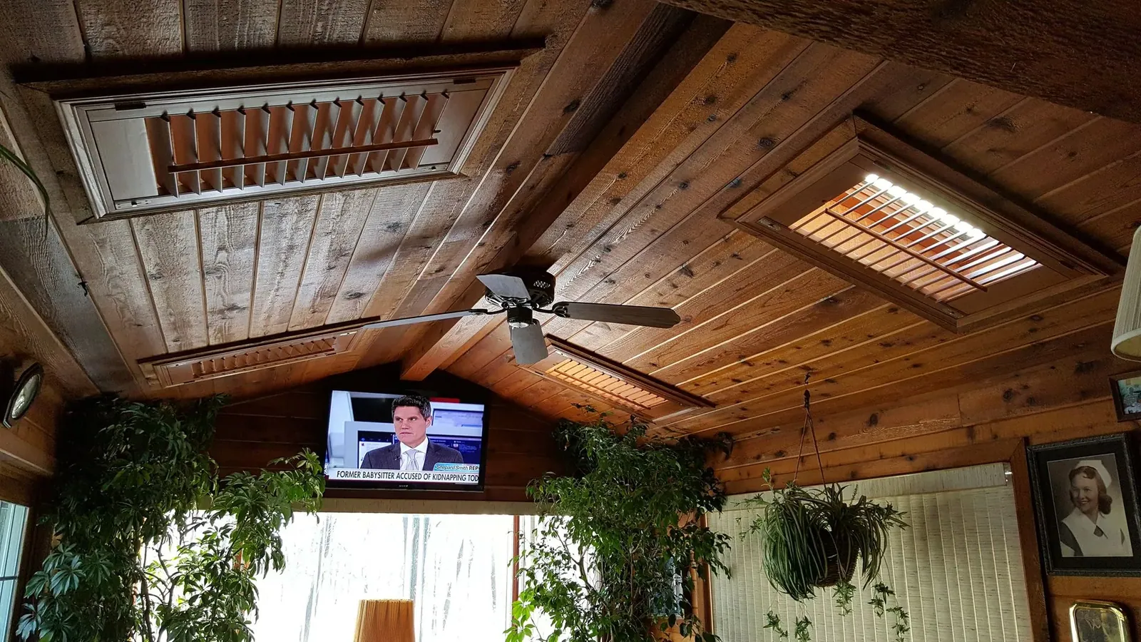 Shutters fitted into skylights in a wood plank ceiling