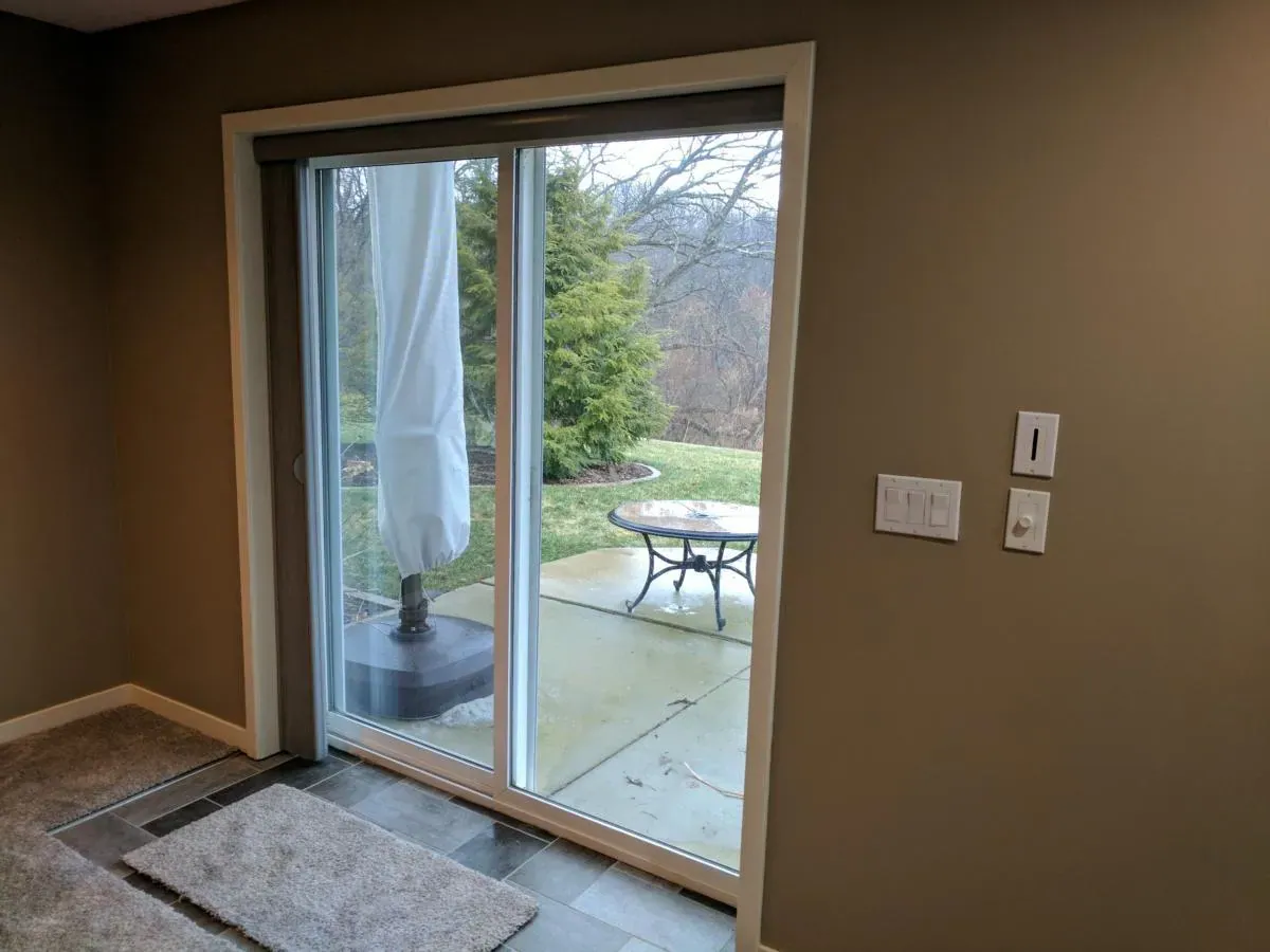 A sliding glass door open to the patio with a Vertical Honeycomb Shade stacked to one side