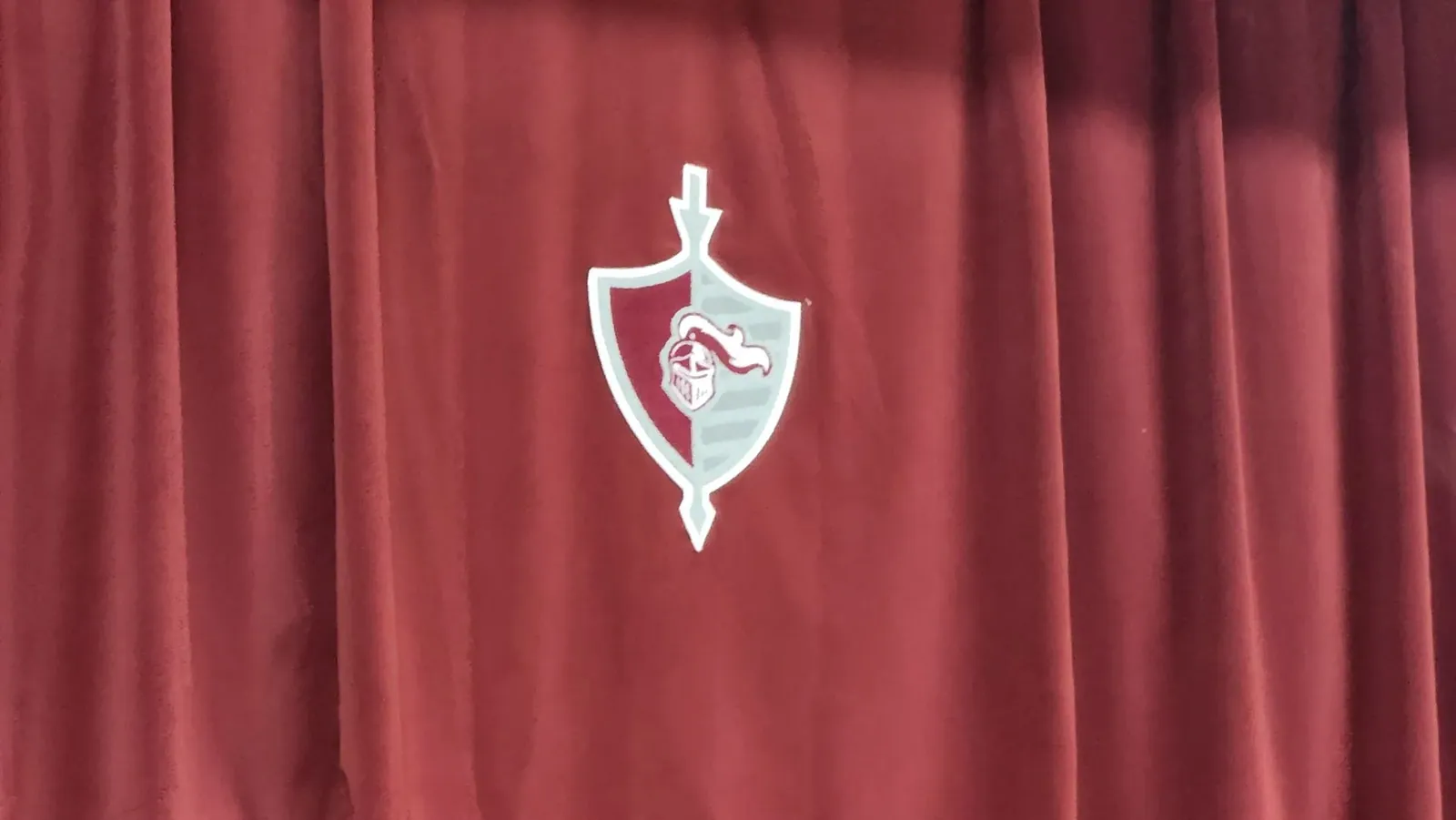 An embroidered crest on a red stage curtain