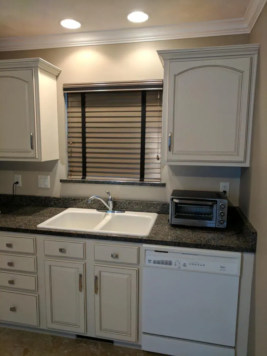 Dark wood blinds on the window over a kitchen sink