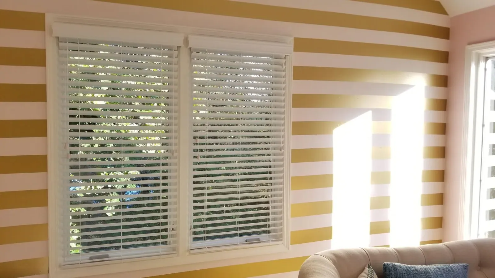 Custom wood & faux wood blinds in a living room, installed by Solar Shield Blinds