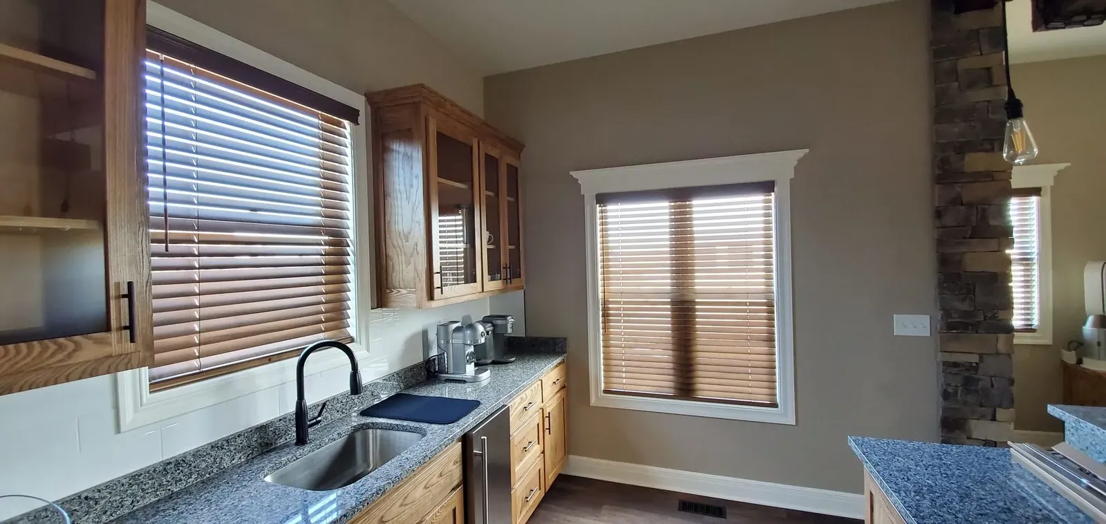 Wood blinds installed in a kitchen by Solar Shield Blinds