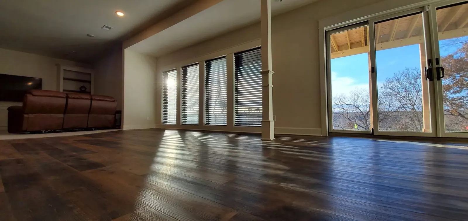 Wood blinds installed across living room windows by Solar Shield Blinds